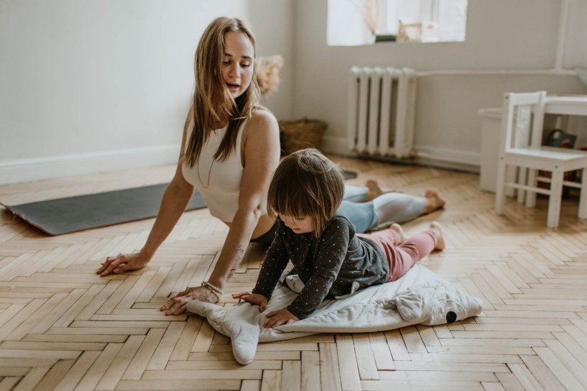 Showing an adult and a child doing cobra yoga pose together