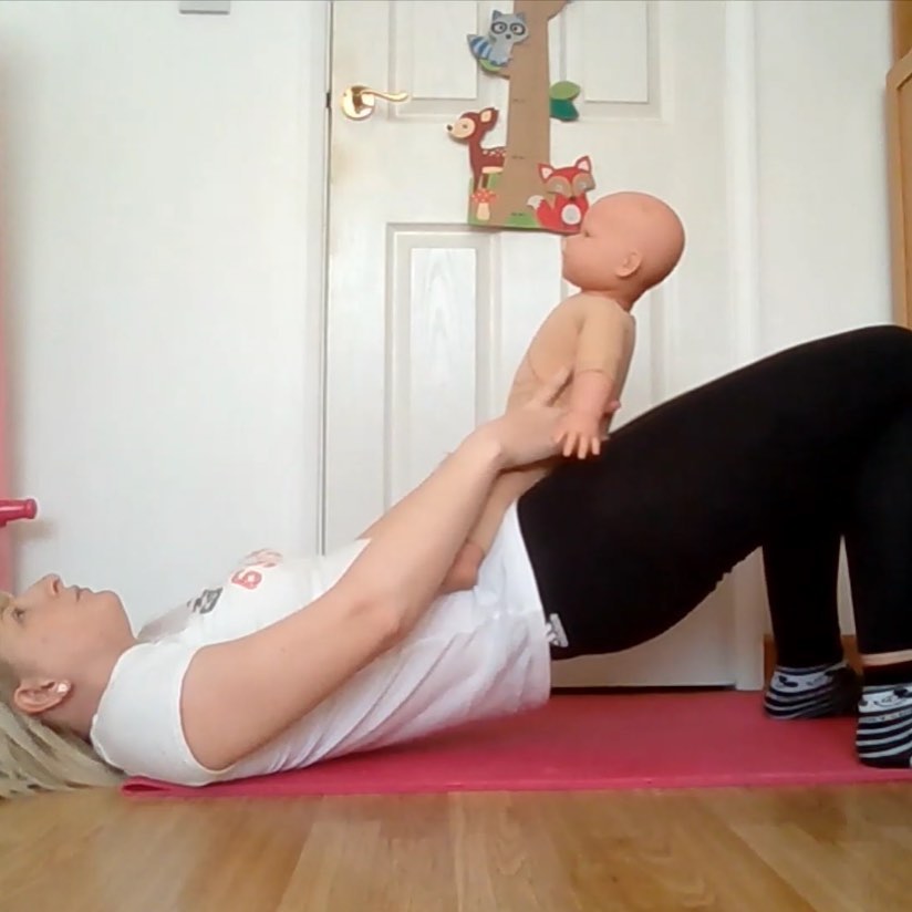 A photo demonstrating baby yoga with a massage doll